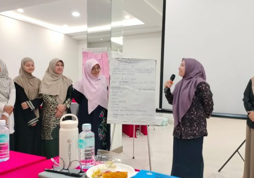 Bendahara sekaligus Advokat YBHK Ummul Ayman, Zuriah, S.Sy., M.H sedang mempresentasikan Peran Ulama Perempuan Aceh dan kiprahnya dari masa ke masa. []